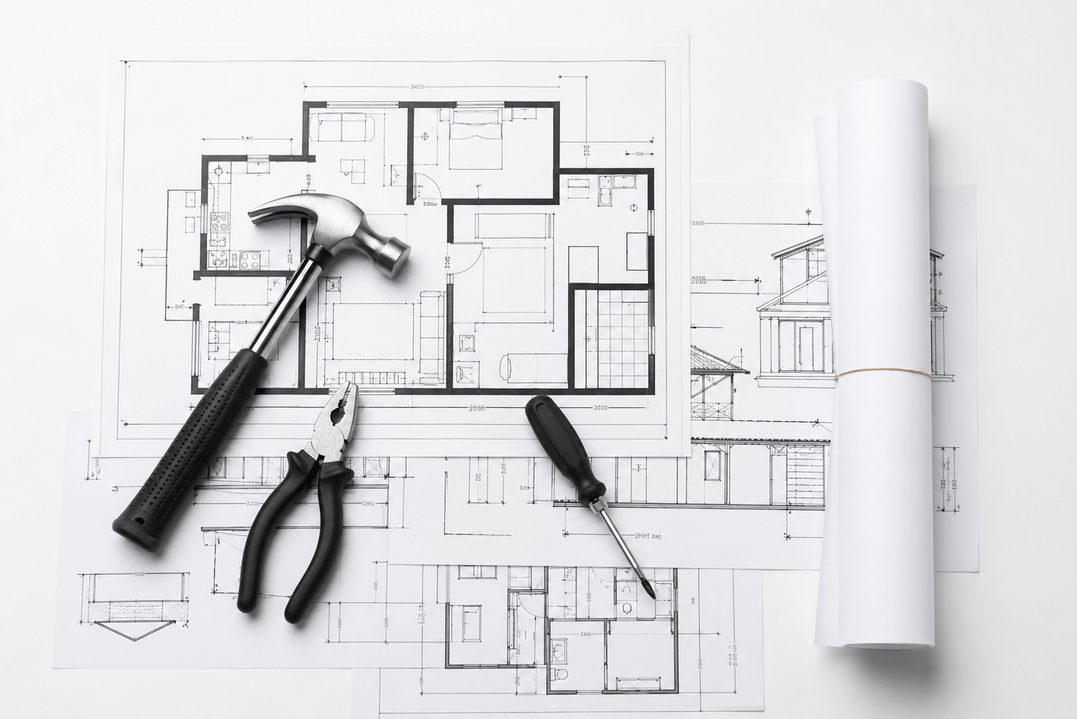 Architectural floor plans and elevations laid out with a hammer, pliers, and screwdriver